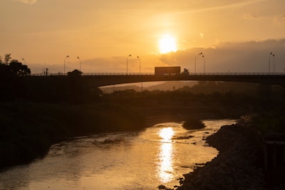 A truck travels across border lines through bridge entry.