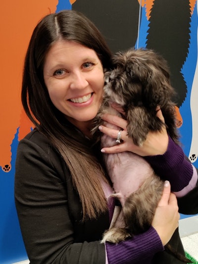 Editor-in-chief Marina Mayer stops to play with puppies in the Puppy Park, sponsored by GEODIS.