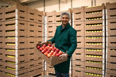 A grocery warehousing worker packs, stores and stacks items.