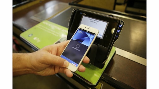 FILE - In this photo taken Friday, Oct. 17, 2014, Eddy Cue, Apple Senior Vice President of Internet Software and Services, demonstrates the new Apple Pay mobile payment system at a Whole Foods store in Cupertino, Calif. More than 200,000 payment locations in the U.S. are equipped to accept so-called contactless payments, including Apple Pay. Smaller merchants tend to be among the several millions that don''t have the required equipment yet. (AP Photo/Eric Risberg, File)