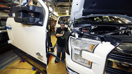 In this Nov. 6, 2014 photo, Shawn Ebeler works on the door assembly on a new Ford F-150 truck is assembled at the Dearborn Truck Plant in Dearborn, Mich. It’s Ford Motor Co.’s biggest bet in decades: an aluminum-sided F-150 that could set a new industry standard _ or cost the company its pickup truck crown. (AP Photo/Carlos Osorio)