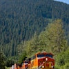 BNSF No. 6674 leads a double-stacked intermodal container train through mountains in the Scenic Subdivision in Washington state. Each double-stack intermodal train can take 280 trucks off the highways, resulting in lower emissions and fuel consumption. A BNSF train can haul one ton of freight 500 miles on one gallon of diesel fuel.