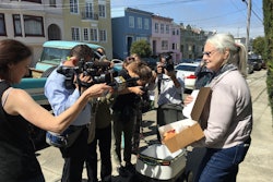 Resident Julie O’Keefe shows off the box of pastries one robot’s lid popped open to reveal for the crowd.