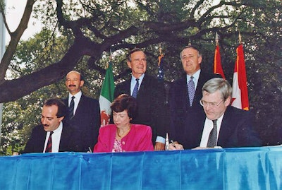 Back row, left to right: Mexican President Carlos Salinas de Gortari, U.S. President George H. W. Bush, and Canadian Prime Minister Brian Mulroney, at the initialing of the draft North American Free Trade Agreement in October 1992. In front are Mexican Secretary of Commerce and Industrial Development Jaime Serra Puche, United States Trade Representative Carla Hills, and Canadian Minister of International Trade Michael Wilson.