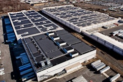 Aerial view of two Amazon fulfillment facilities with solar systems on their rooftops.