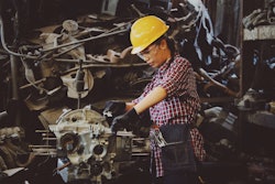 Woman Wears Yellow Hard Hat Holding Vehicle Part 1108101