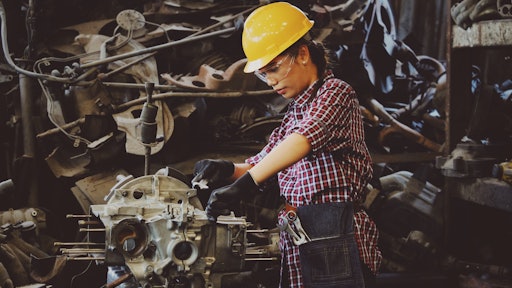 Woman Wears Yellow Hard Hat Holding Vehicle Part 1108101