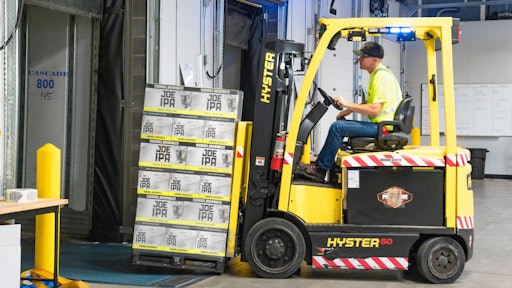 Man Riding A Yellow Forklift With Boxes 1267324
