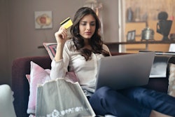 Woman Holding Card While Operating Silver Laptop 919436 (1)