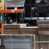 Forklift loaded with stacked porcelain tile boxes in warehouse with orange industrial shelving