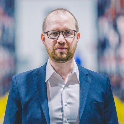 Professional man in blue blazer and glasses with blurred office background