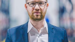 Professional man in blue blazer and glasses with blurred office background