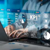 Professional analyzing KPI metrics on laptop with holographic business dashboard displaying charts, graphs, and analytics data