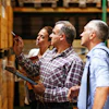 Warehouse workers reviewing inventory boxes on shelves in a storage facility