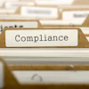 Beige file folder tab labeled 'Compliance' among other organizational documents