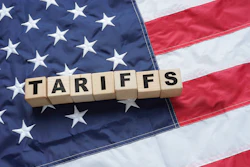 Wooden letter tiles spelling 'TARIFFS' arranged on the American flag background