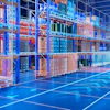 Futuristic blue and orange warehouse interior with glass partitions and grid-patterned flooring under neon lighting
