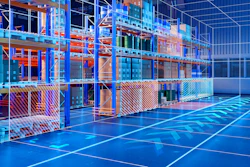 Futuristic blue and orange warehouse interior with glass partitions and grid-patterned flooring under neon lighting