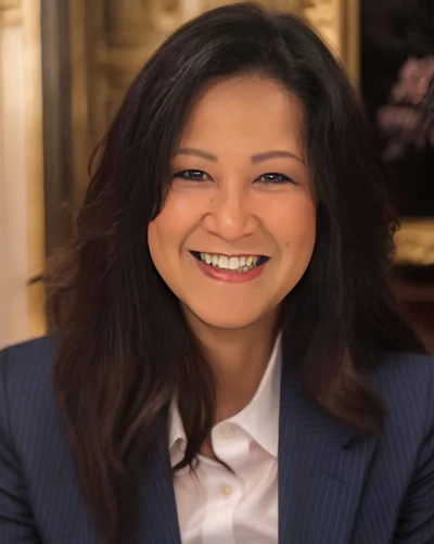 Professional woman in navy blazer smiling at camera in office setting