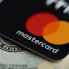 Mastercard credit card displayed on U.S. currency showing red and orange overlapping circles logo