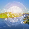 Digital globe with network nodes overlaid on scenic landscape with mountains, water, and green terrain representing global connectivity