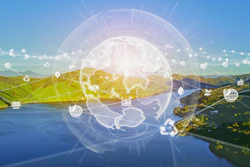 Digital globe with network nodes overlaid on scenic landscape with mountains, water, and green terrain representing global connectivity