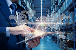 Businessman holding tablet in warehouse with holographic world map and global network visualization overlay