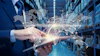 Businessman holding tablet in warehouse with holographic world map and global network visualization overlay