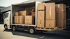 White delivery truck loaded with stacked cardboard boxes on wooden pallets in warehouse setting