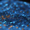 Abstract digital visualization with blue and orange particles flowing across circuit board patterns on dark background
