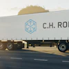 C.H. Robinson refrigerated truck traveling on highway at sunset with trees in background
