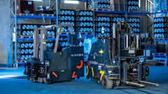 GIDEON branded forklifts displayed in a modern blue-lit warehouse with stacked plastic crates