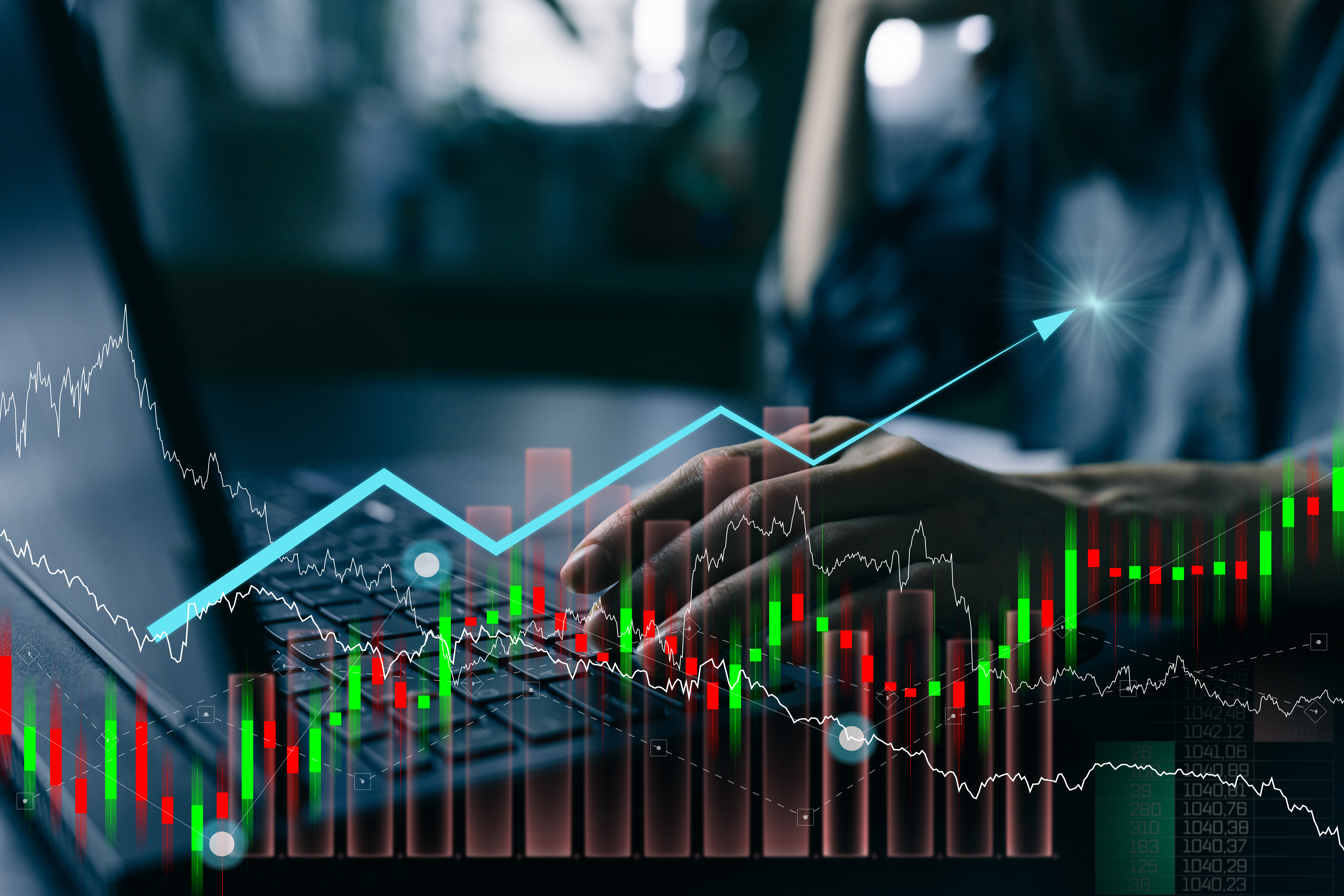 Financial stock market charts with candlestick graphs, upward trend lines, and trading data visualization on blurred business background