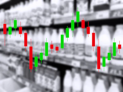 Candlestick chart with red and green bars showing financial market price movements overlaid on industrial warehouse background