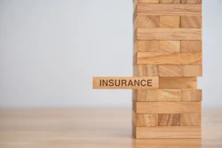 Wooden block tower with 'Insurance' text block representing financial stability and risk management