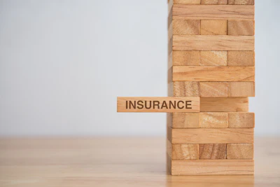 Wooden block tower with 'Insurance' text block representing financial stability and risk management