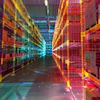 Futuristic data center corridor with glowing neon grid patterns in orange, red, and cyan lights
